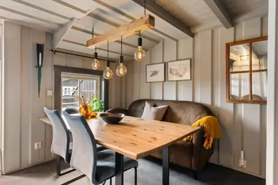 a dining room with a wooden table and a couch at Cozy Skilodge ski in & out in Trysil in Trysil
