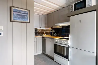 a kitchen with white cabinets and a white refrigerator at Cozy Skilodge ski in & out in Trysil in Trysil
