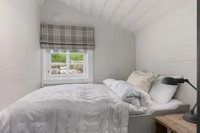 a white bedroom with a bed and a window at Trysilfjell Nord 1105C - by Vacation Trysil in Trysil