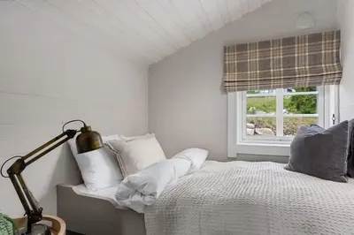 a white bedroom with a bed and a window at Trysilfjell Nord 1105C - by Vacation Trysil in Trysil