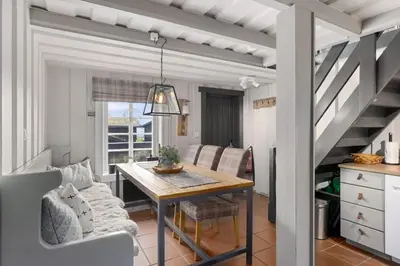 a living room with a dining room table and stairs at Trysilfjell Nord 1105C - by Vacation Trysil in Trysil
