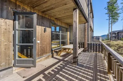 a wooden house with a deck with a bench at Trysilfjell 24 by Vacation Trysil in Trysil