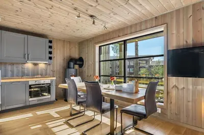 a kitchen with a table and chairs and a large window at Trysilfjell 24 by Vacation Trysil in Trysil