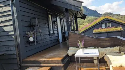 a wooden deck with a table and a house at Ski-In, Ski-Out apartment at Filefjell in Tyinkrysset