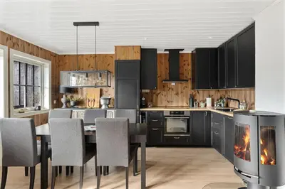 a kitchen with a dining table and a fireplace at Trysilfjell 786 by Vacation Trysil in Trysil