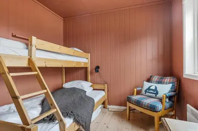 a bedroom with two bunk beds and a chair at Trysilfjell 782 by Vacation Trysil in Trysil