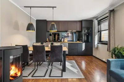 a kitchen and dining room with a table and a fireplace at Trysilfjell 33 by Vacation Trysil in Trysil