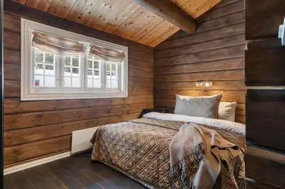 a bedroom with wooden walls and a bed and a window at Trysilfjell 636 by Vacation Trysil in Trysil
