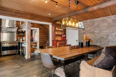 a dining room with a wooden table and a kitchen at Trysilfjell 636 by Vacation Trysil in Trysil