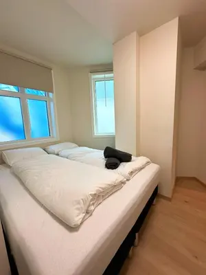 a room with three beds in it with a window at Aurum Bergen Apartment in Bergen