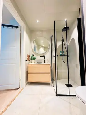 a bathroom with a shower and a sink and a mirror at Aurum Bergen Apartment in Bergen