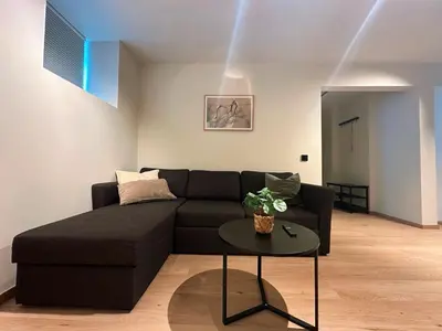 a living room with a black couch and a table at Aurum Bergen Apartment in Bergen