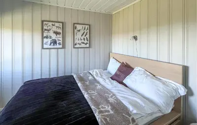 a bed in a bedroom with three pictures on the wall at 3 Bedroom Stunning Home In Lillehammer in Lillehammer