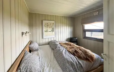a bedroom with a bed in the corner of a room at 3 Bedroom Stunning Home In Lillehammer in Lillehammer