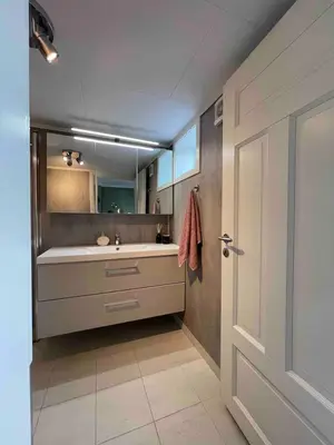 a bathroom with a tub and a sink and a mirror at Trivelig lite hus in Lii