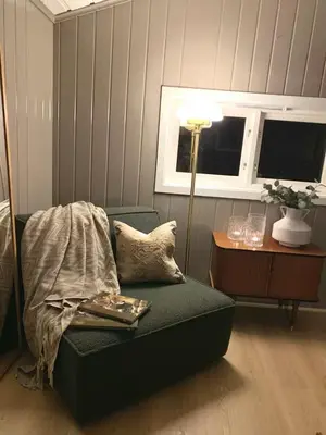 a living room with a green couch and a table at Trivelig lite hus in Lii