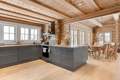 a kitchen with gray cabinets and a dining room with a table at Trysilfjell 25 by Vacation Trysil in Trysil