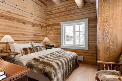 a log cabin bedroom with a bed and a window at Trysilfjell 25 by Vacation Trysil in Trysil