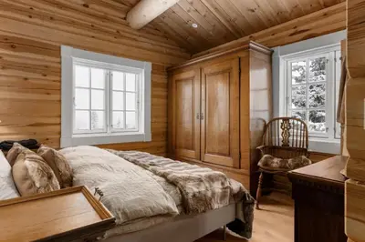 a bedroom with wooden walls and a bed and a chair at Trysilfjell 25 by Vacation Trysil in Trysil