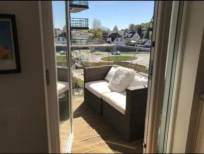 a couch on a balcony with a view of a street at Lys leilighet på Kaldnes in Lii