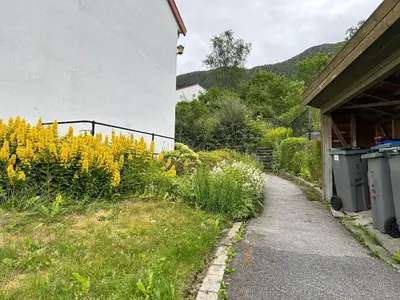 a garden with yellow flowers next to a building at Family-friendly townhouse on Landås in Lii