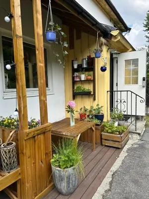 a wooden deck with a table and potted plants at Family-friendly townhouse on Landås in Lii