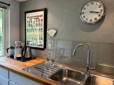 a kitchen with a sink and a clock on the wall at Family-friendly townhouse on Landås in Lii