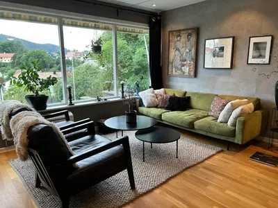 a living room with a green couch and a table at Family-friendly townhouse on Landås in Lii