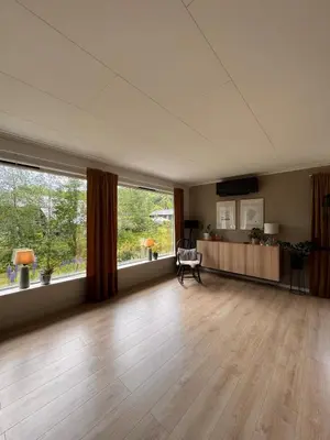 an empty living room with wooden floors and large windows at Martine's home in Lii