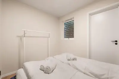 a white bedroom with towels on a bed at City Apartment I Cozy with Perfect Location in Bergen