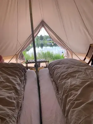 a tent with two beds in it with a view at Glampingtelt i fjordkanten, Rønlund Hyttepark in Ron