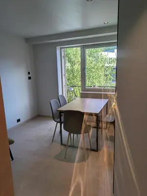 a dining room with a table and chairs and a window at Apartment in the middle of the city center in a quiet street in Stryn