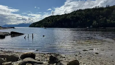 a large body of water with rocks and trees at Cabin by the lake with 3 bedrooms in Kvam