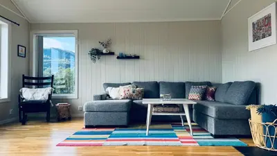 a living room with a blue couch and a table at Cabin by the lake with 3 bedrooms in Kvam