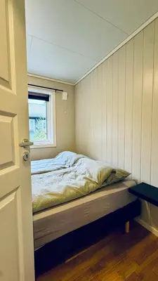 a bedroom with a bed in a room with a window at Cabin by the lake with 3 bedrooms in Kvam