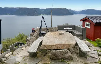 a bench and a table with a view of a lake at Stunning Home In Lavik in Lavik