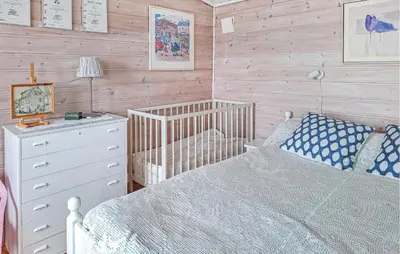 a bedroom with a crib and a bed and a dresser at Stunning Home In Lavik in Lavik