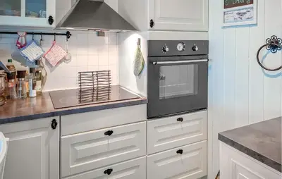 a kitchen with white cabinets and a stove at Stunning Home In Lavik in Lavik