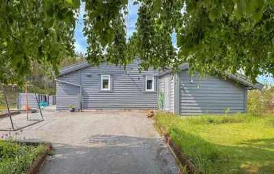 a gray house with a playground in front of it at 3 Bedroom Gorgeous Home In Kolbeinsvik in Kolbeinsvik