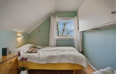 a small bedroom with a bed and a window at Amazing Home In Rong With Ethernet Internet in Rong