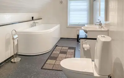 a bathroom with a tub and a toilet and a sink at Pet Friendly Home In Eidsvåg I Romsdal in Eidsvåg