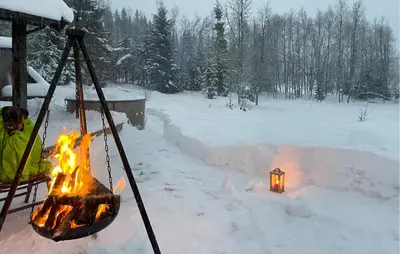 a person standing next to a fire in the snow at Awesome Home In Trysil With Sauna in Trysil