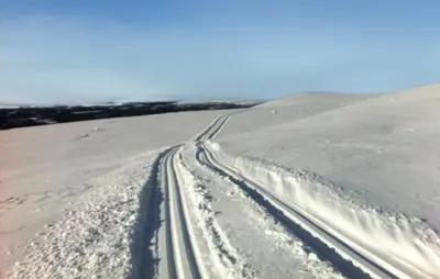 a snow covered road with tire tracks in a field at Awesome Home In Trysil With Sauna in Trysil