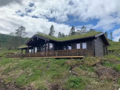 a house with a grass roof on top of a hill at Moderne og romslig familiehytte i Stryn in Stryn