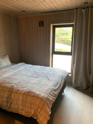 a bedroom with a bed and a window at Moderne og romslig familiehytte i Stryn in Stryn