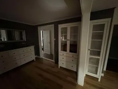 an empty room with white cabinets and drawers at KSU Topleiligheten in Kristiansund