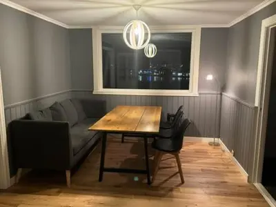 a living room with a table and a couch at KSU Topleiligheten in Kristiansund