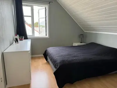a bedroom with a bed and a window at KSU Topleiligheten in Kristiansund