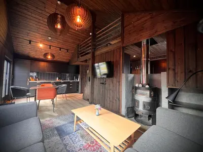 a living room with a table and a stove at Hytte på Norefjell in Surteberg