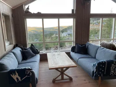 a living room with blue couches and a table at MYLLA - New cabin - Sauna - Hike - Bike - Canoe- Fishing in Jevnaker